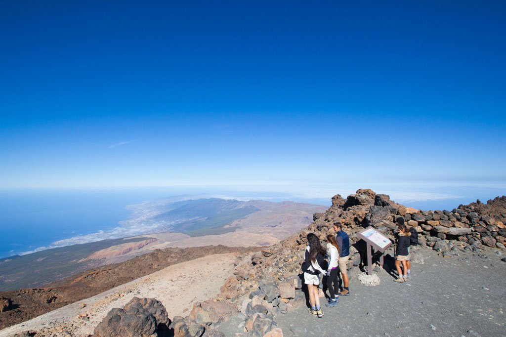 Des gens lisant une affiche d’information dans le paysage du mont Teide, à Tenerife.