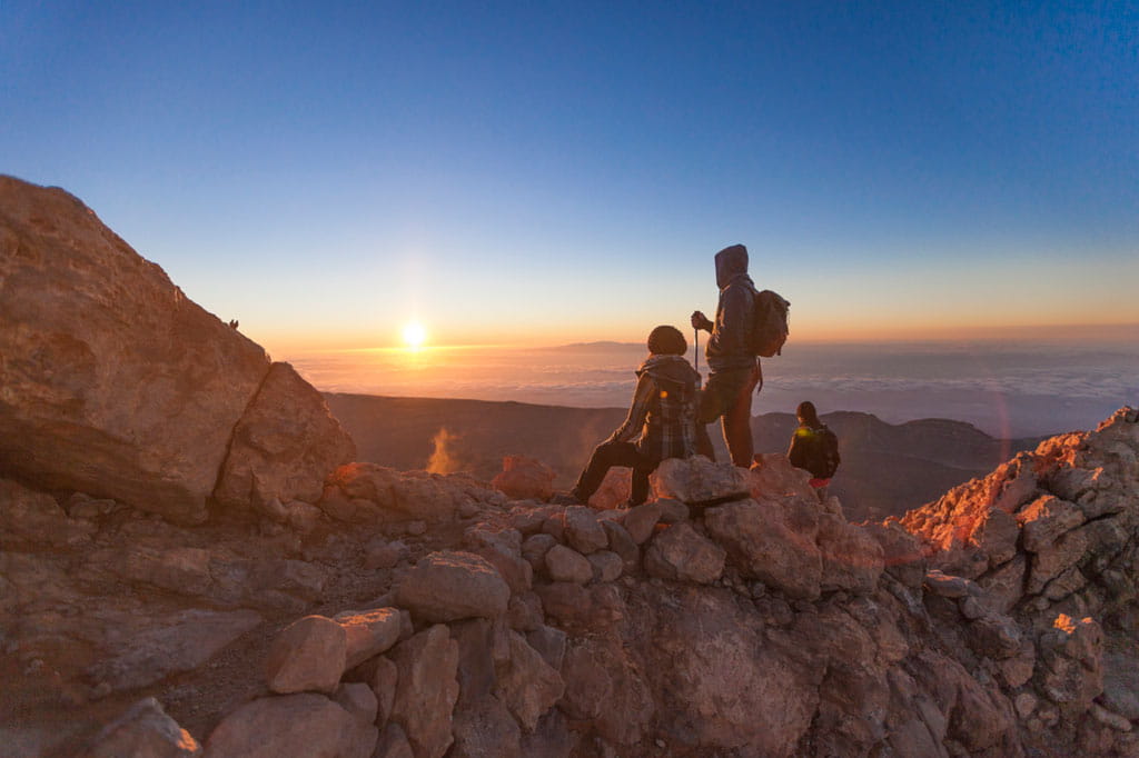 Des gens regardant le lever du soleil au sommet du mont Teide, à Tenerife.