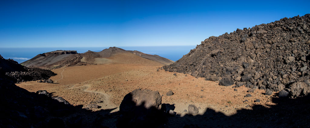Paysage volcanique sur le mont Teide, à Tenerife, avec un ciel clair et des horizons visibles.