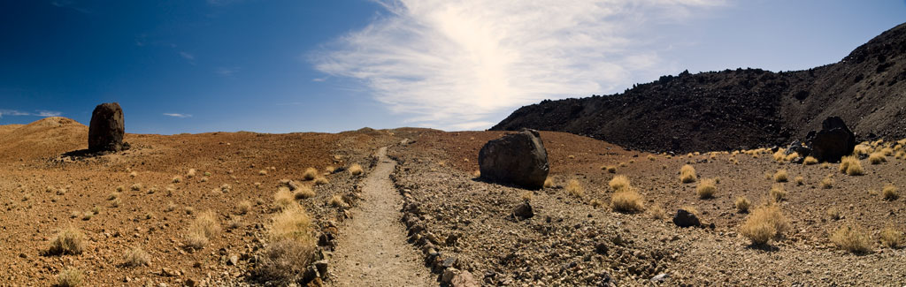 Sentier dans un paysage volcanique aride avec de grands rochers dans le parc national de la Teide, Tenerife.