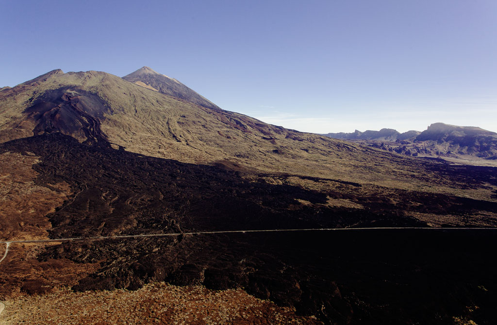 Paysage du mont Teide à Tenerife, avec un terrain volcanique et un ciel dégagé.