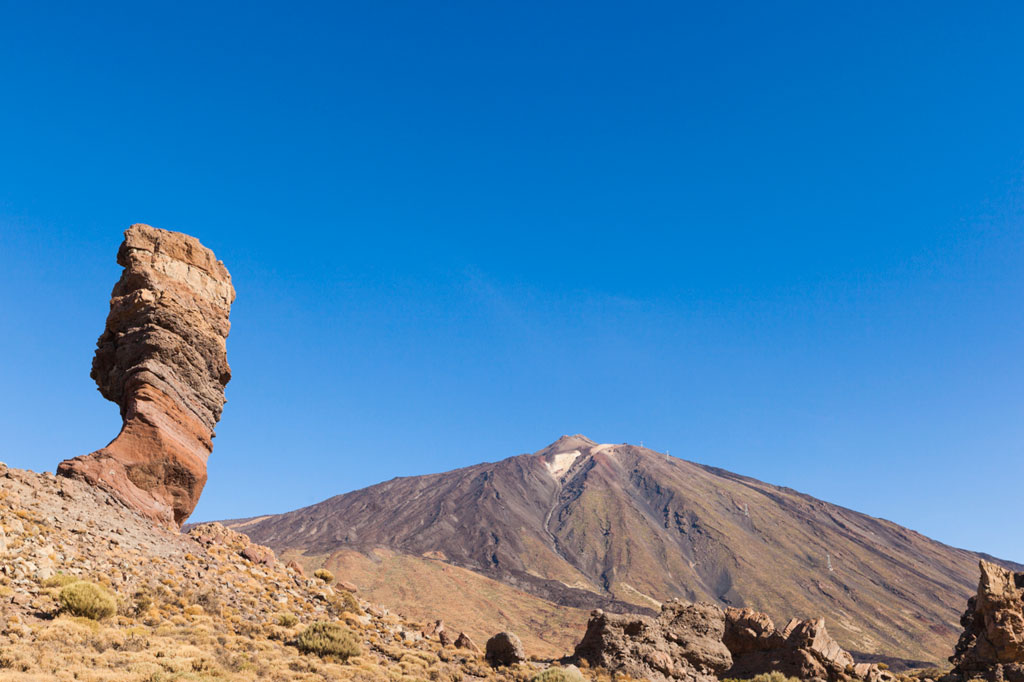 Roque Cinchado avec le mont Teide en arrière-plan à Tenerife sous un ciel clair.