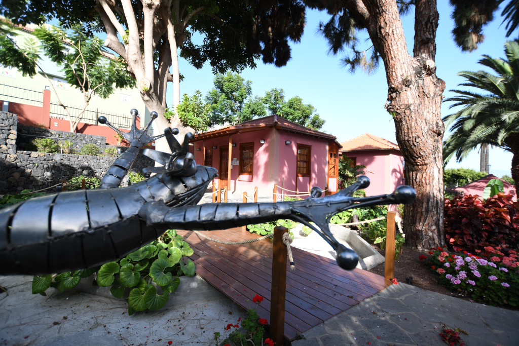 Sculpture de lézard métallique devant une maison rose à Puerto de la Cruz, Tenerife.