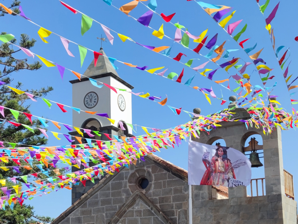 Le clocher de l’église à Tenerife avec des fanions colorés et le drapeau de Santa Úrsula.