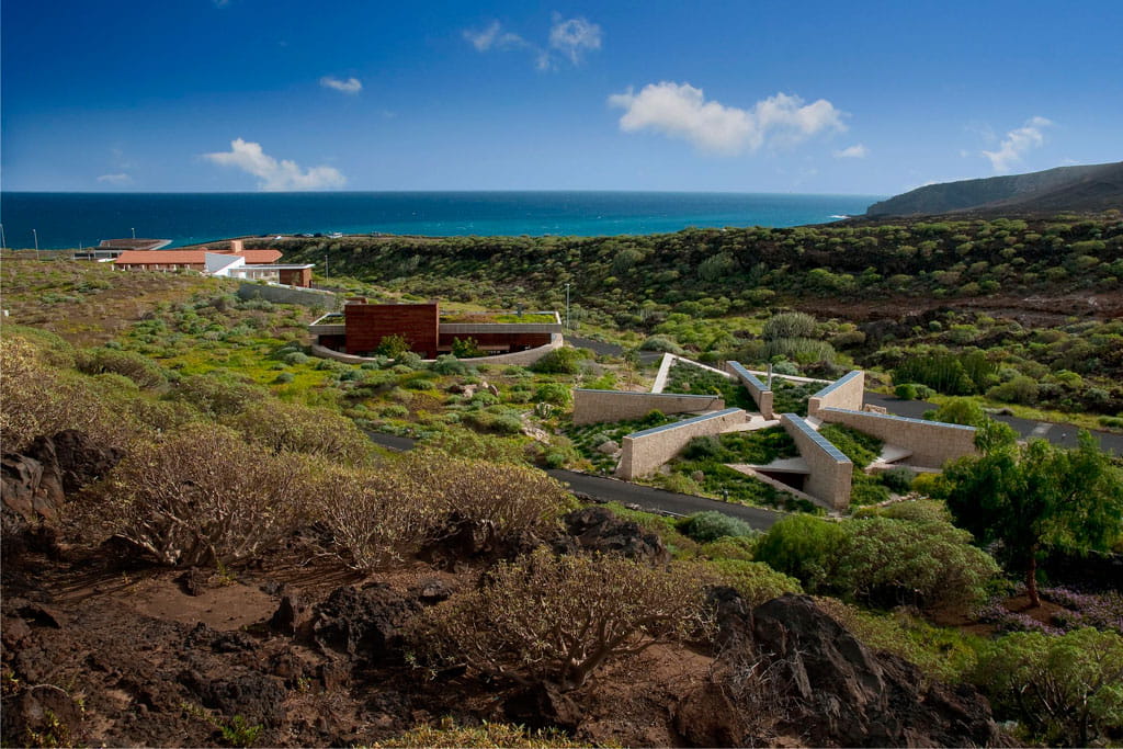 Centre d’accueil à Punta de Teno, Tenerife, entouré de verdure et de mer en arrière-plan.