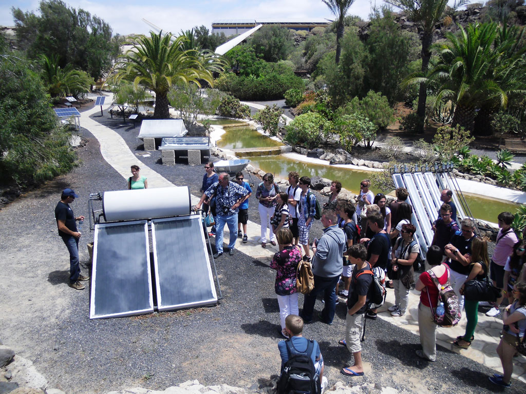 Groupe de personnes observant des panneaux solaires dans un parc à Tenerife.