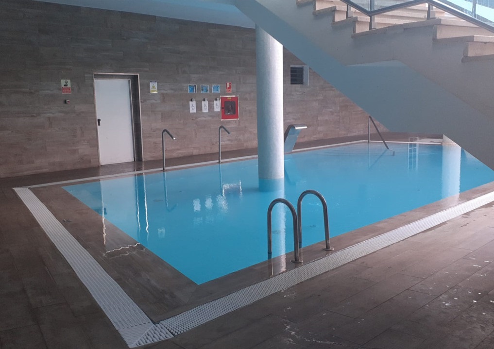 Piscine intérieure avec escaliers et panneaux accrochés au mur à Tenerife.