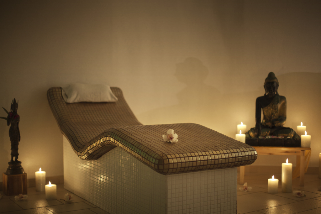 Table de massage avec bougies et statue dans un spa à Tenerife.