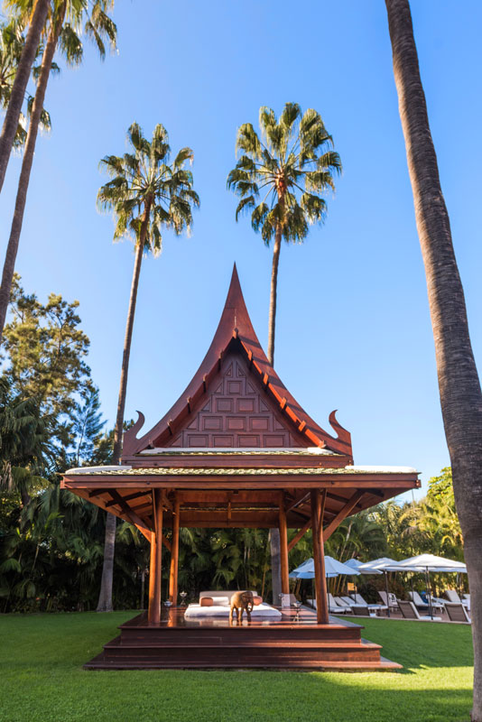 Bâtiment en bois au toit pointu, entouré de palmiers à Tenerife.